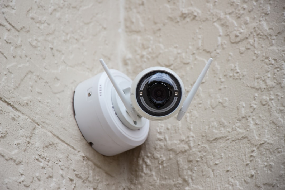 white-surveillance-camera-hanging-on-wall-knt4zd8hpb0